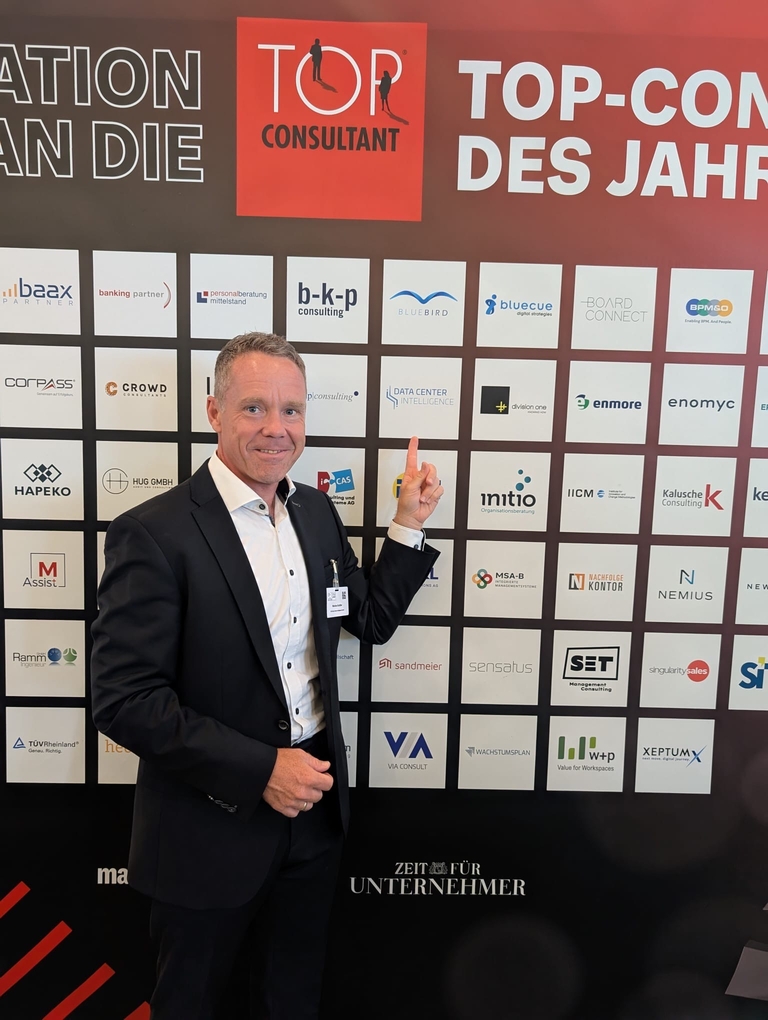 Markus Schäfer vor Partnerwand auf dem TOP CONSULTANT-Event 2025